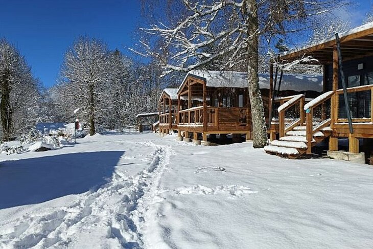 Chalets sous la neige dans les campings Sites et Paysages, parfaits pour se ressourcer avec des escapades hivernales.